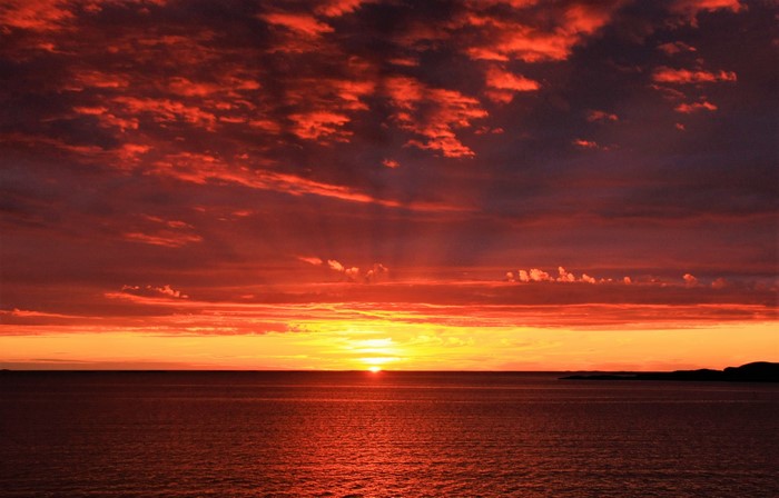 Sunset over the ocean with dramatic clouds