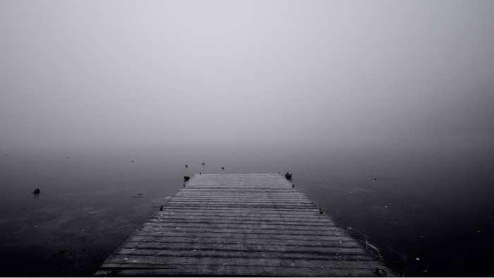 Pier in fog over water
