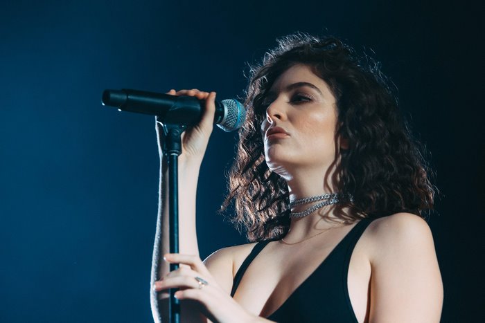 Lorde singing into a microphone on stage