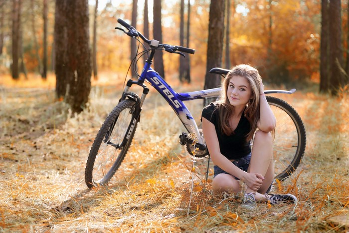 Girl with Stels bicycle in autumn forest