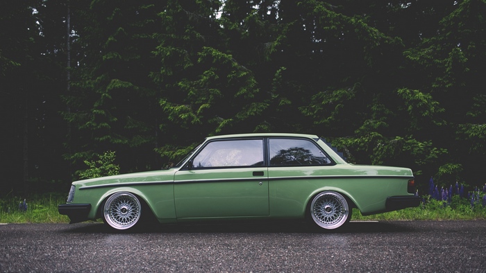 Green vintage Volvo car parked on a wet road