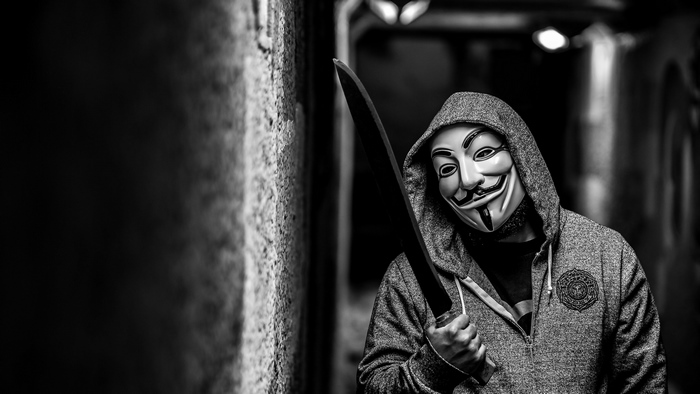 Masked Figure Holding Sword in Dark Alley