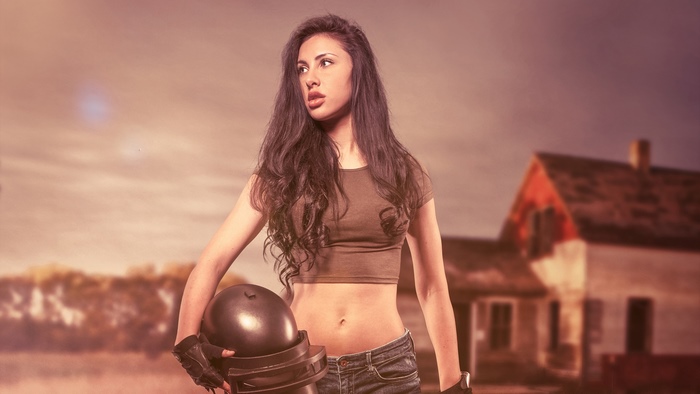 Woman in crop top and jeans holding PUBG helmet