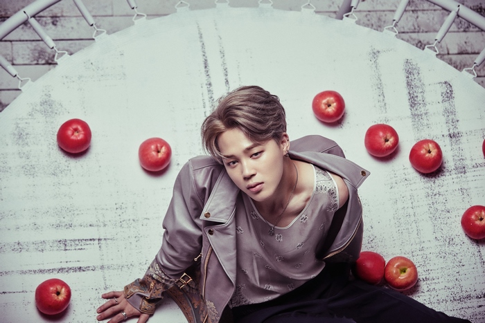 Jimin from BTS sitting with apples