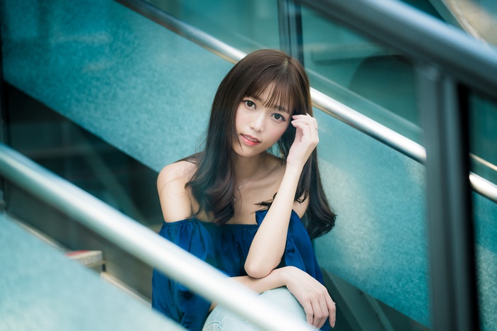 Asian woman with brown hair sitting on stairs