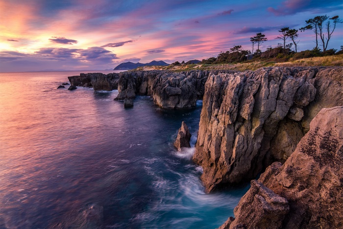 Rocky coastline at sunset with colorful sky