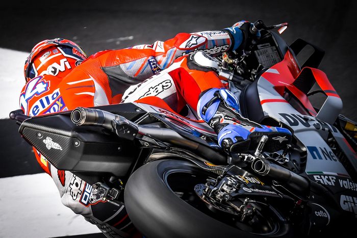 Motorcyclist in Ducati Corse racing suit on a Ducati motorcycle
