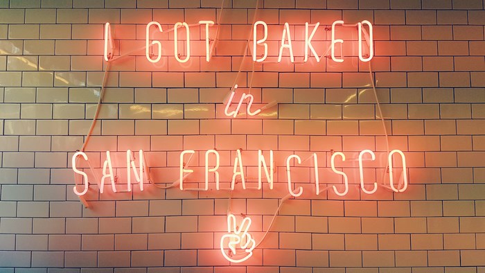 Neon sign "I got baked in San Francisco" with peace sign