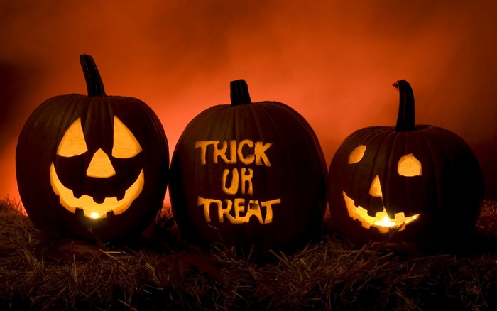Three carved Halloween pumpkins with glowing lights