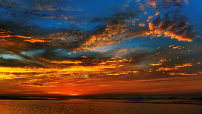 Sunset over the ocean with dramatic clouds
