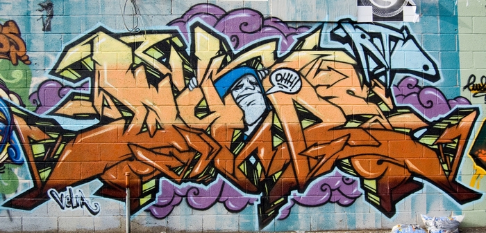 Graffiti art with cartoon character on brick wall