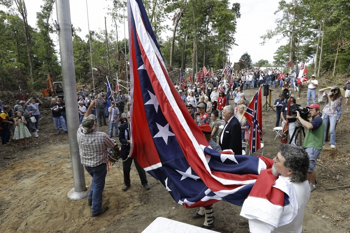 Confederate flags being raised by a crowd