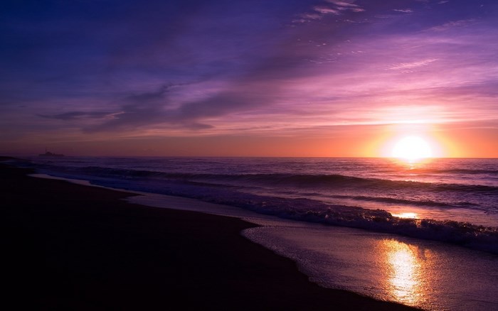 Sunset over the ocean with purple and orange sky