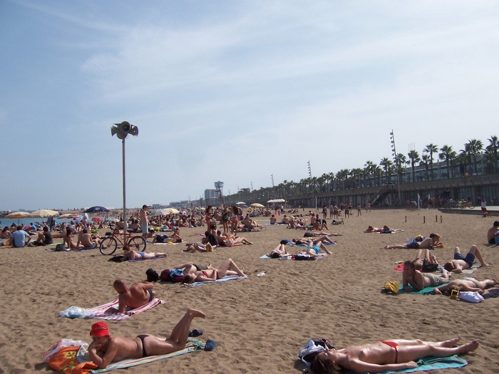 People sunbathing on a crowded beach in Barcelona