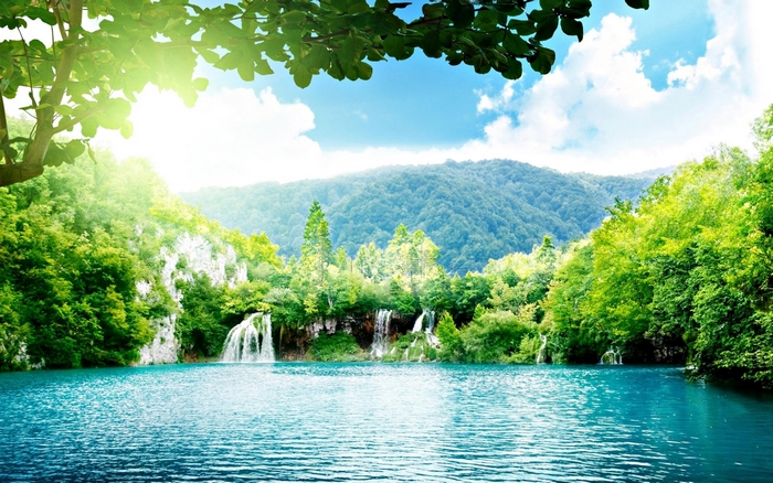 Turquoise lake with waterfalls and green mountains
