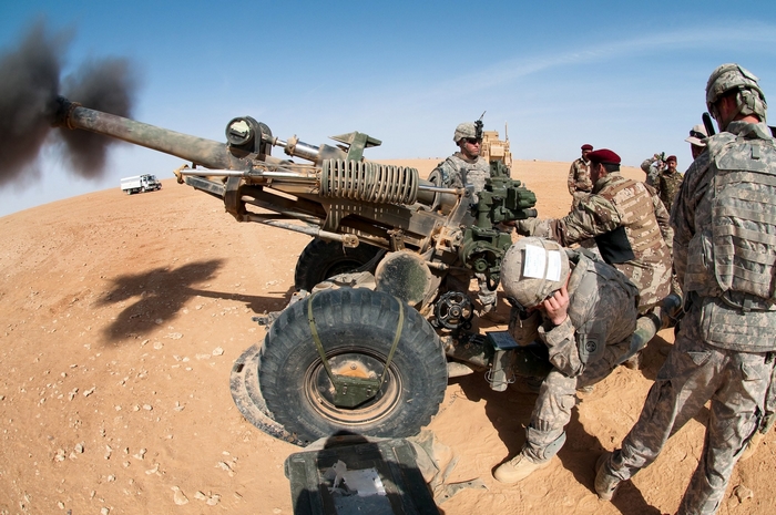 Soldiers firing artillery in desert