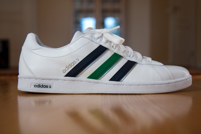 White Adidas sneakers with navy and green stripes