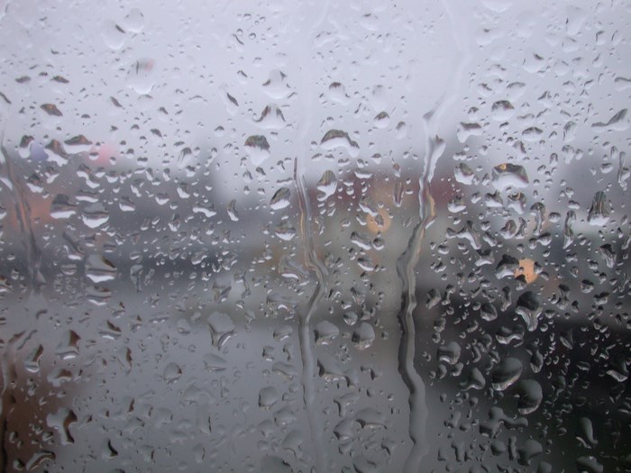 Raindrops on a window with blurred city background