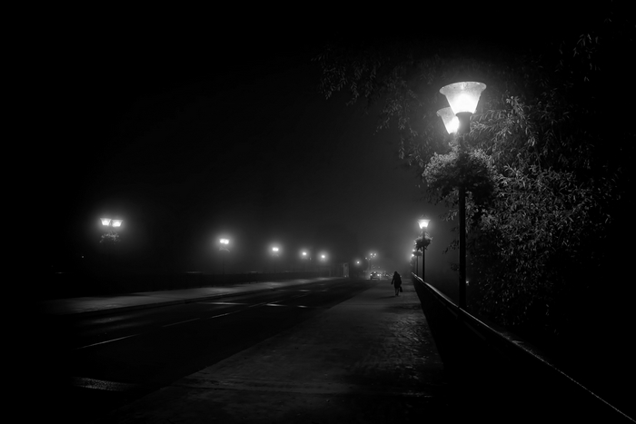 Night street with lampposts and fog