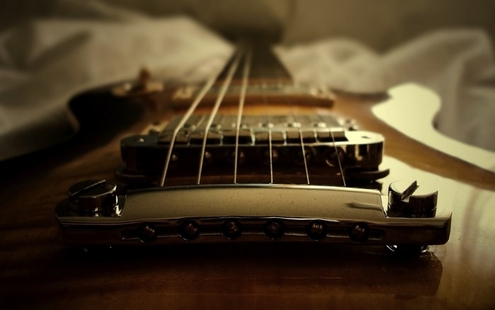 Close-up of an electric guitar bridge and strings
