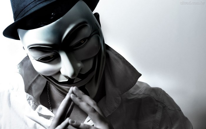 Man wearing Guy Fawkes mask and hat
