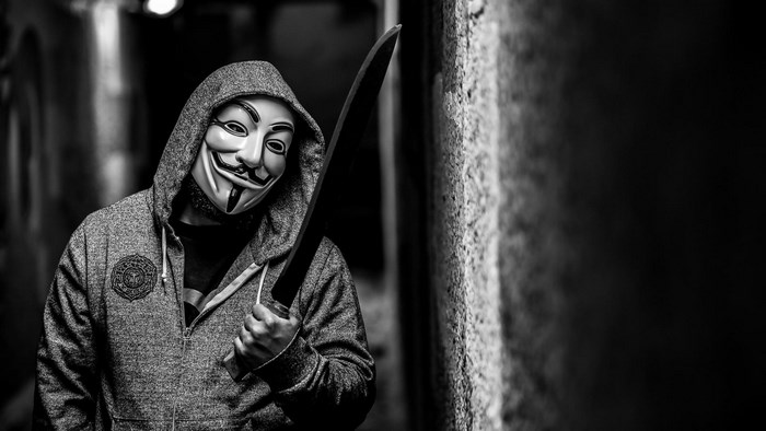 Anonymous Masked Figure with Machete in Dark Alley