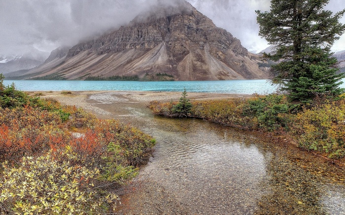 Mountain lake with stream and autumn foliage