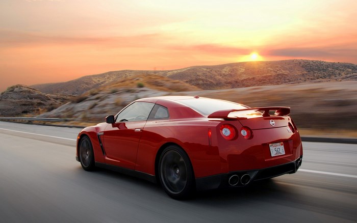 Red Nissan GT-R Driving on a Desert Road at Sunset