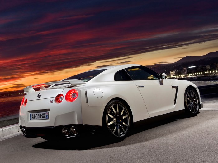 White Nissan GT-R parked by the sea at sunset