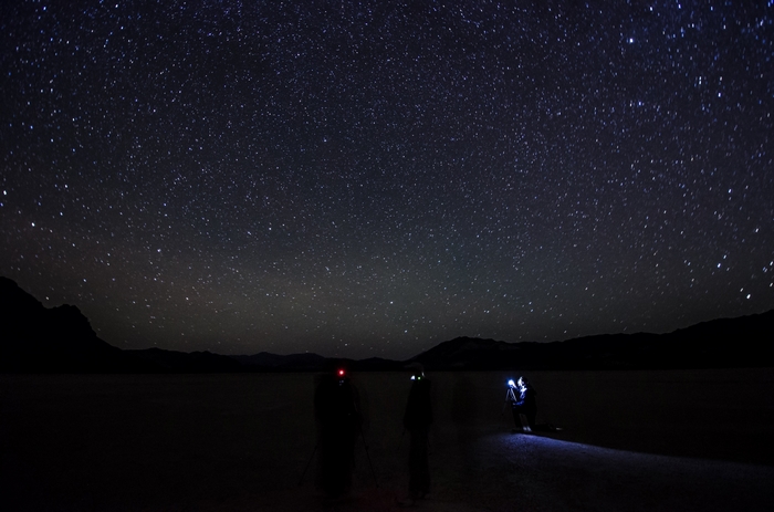 People stargazing on a dark plain