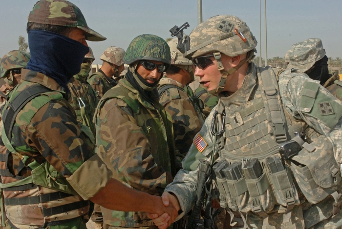 US Army soldiers shaking hands in a desert environment