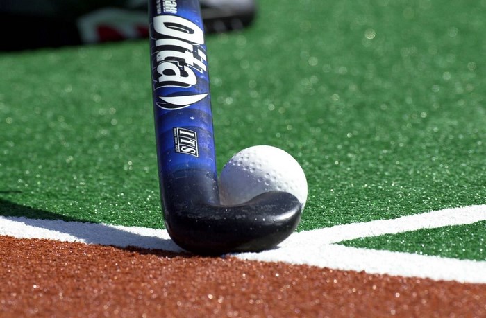 Field hockey stick and ball on turf