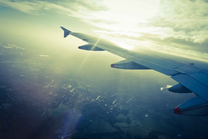 Airplane wing over a city at sunset