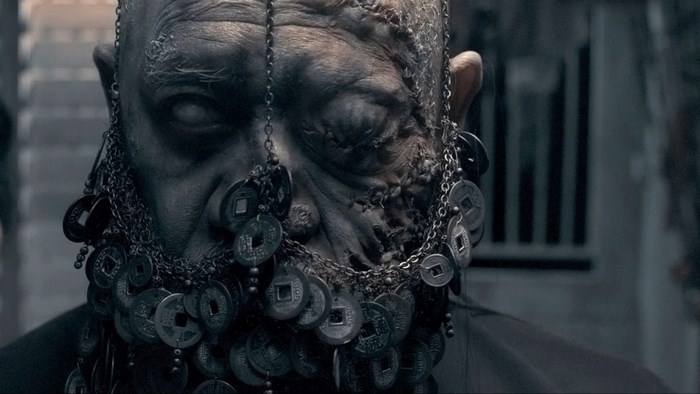 Close-up of a grotesque man with coins in his beard