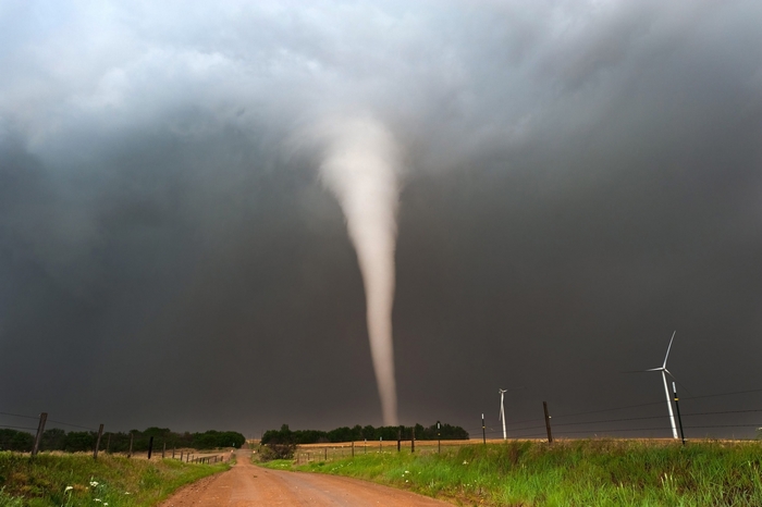 Tornado over a rural landscape with wind turbines
