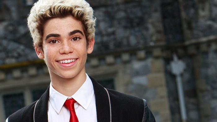 Cameron Boyce smiling in a suit