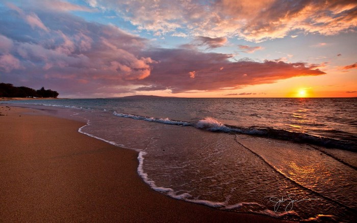 Sunset Beach with Vibrant Clouds and Gentle Waves