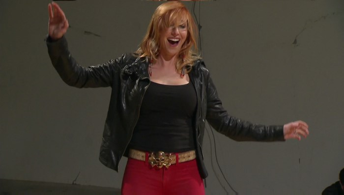 Kari Byron in a black jacket and red pants