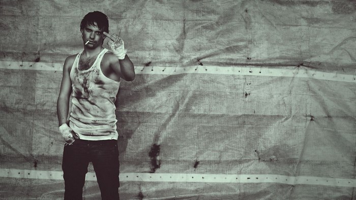 Man in dirty tank top with cigarette and boxing wraps
