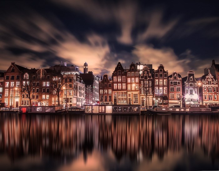 Amsterdam canal houses at night with reflections