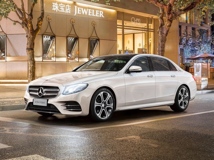 White Mercedes-Benz E-Class L parked in front of a jewelry store