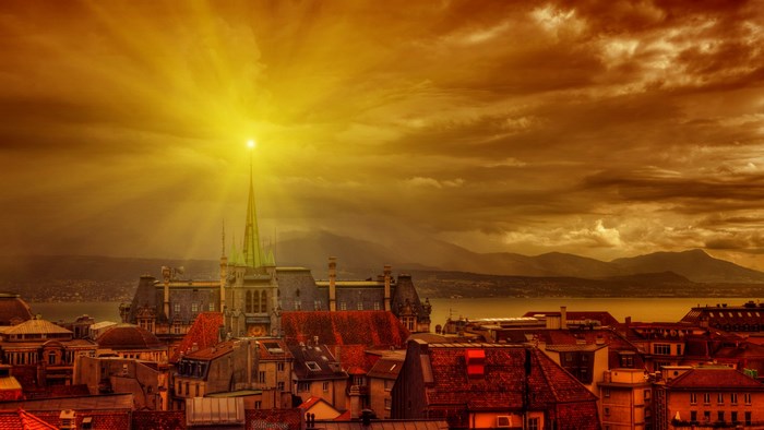 Cityscape with church spire and mountains
