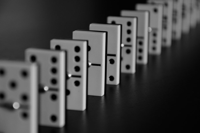 A line of dominoes on a dark surface
