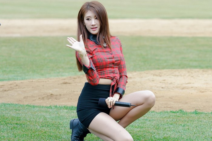 Korean girl group member kneeling on grass