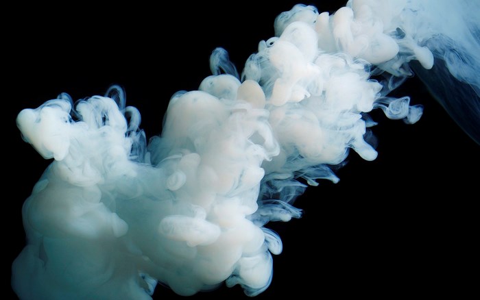 White smoke swirling against black background