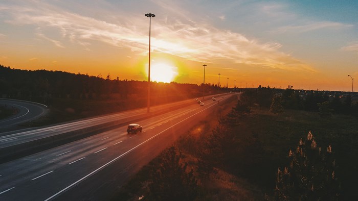 Highway at sunset with cars and streetlights