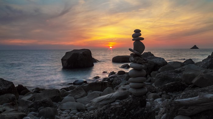 Stone cairn on a rocky beach at sunset