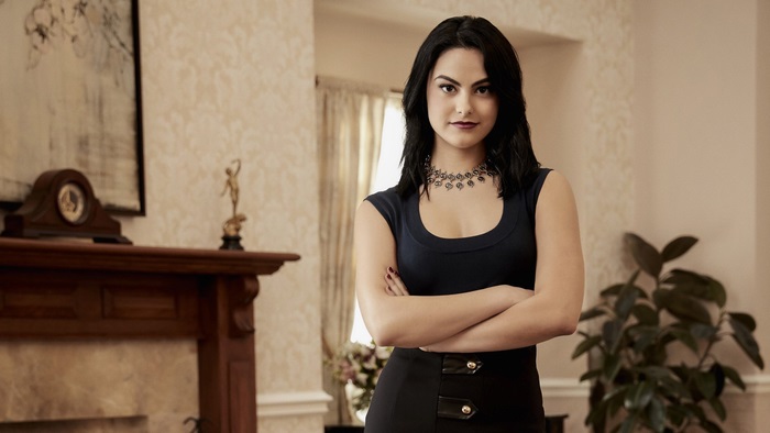 Camila Mendes in a dark blue top and black skirt