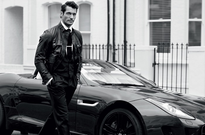 David Gandy in a black leather jacket and suit with a car
