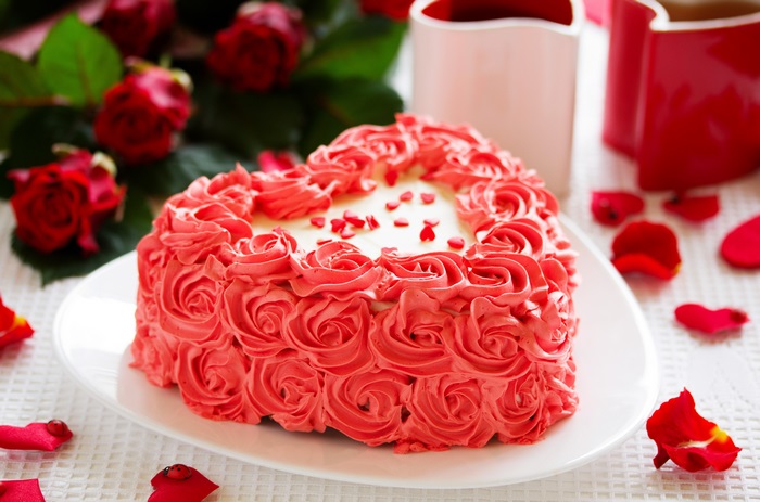 Heart-shaped cake with pink frosting and roses